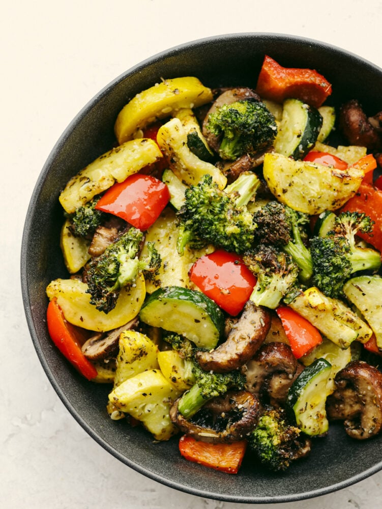 Cooking your vegetables in an air fryer doesn't get much easier (or more delicious!) than this! Crispy and tender, these veggies will be the best side dish that you've ever had! Cooked air fryer vegetables in a dish.