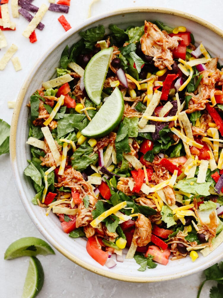 This BBQ chicken salad is healthy and packed to the brim with flavor! Filled with veggies, shredded chicken, and crispy tortilla chips, this salad really takes off when you add in the dressing. It's to die for! A bowl of BBQ chicken salad.