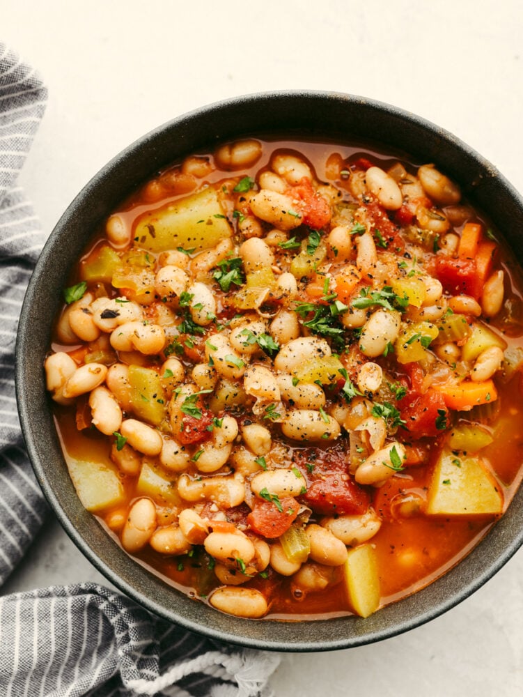 This white bean stew is a classic recipe that will fill your belly and warm you right up! With the insanely delicious flavor, this hearty stew will be your guests' favorite and fly off the table! A bowl of bean stew.