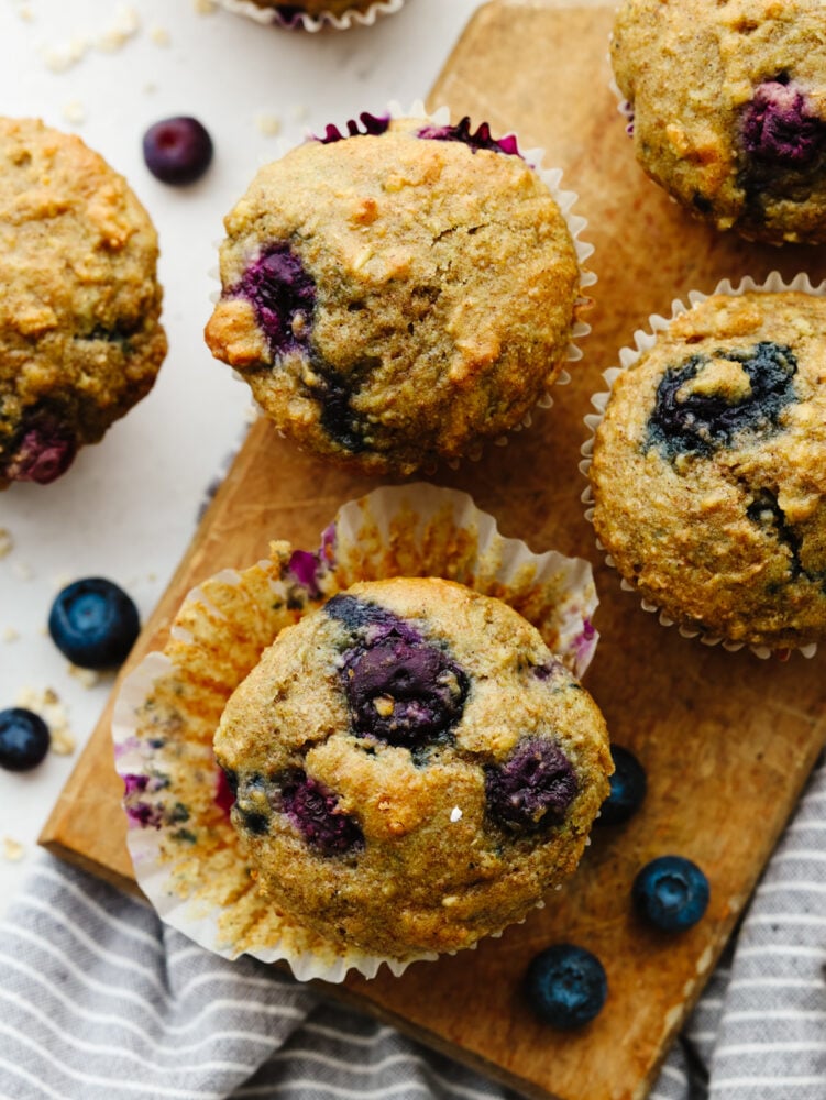 These blueberry oatmeal muffins are a healthy, hearty snack or breakfast loaded with whole grains and bursting berries! They're a delicious way to give you energy throughout your busy days! Closeup of a few blueberry oatmeal muffins.
