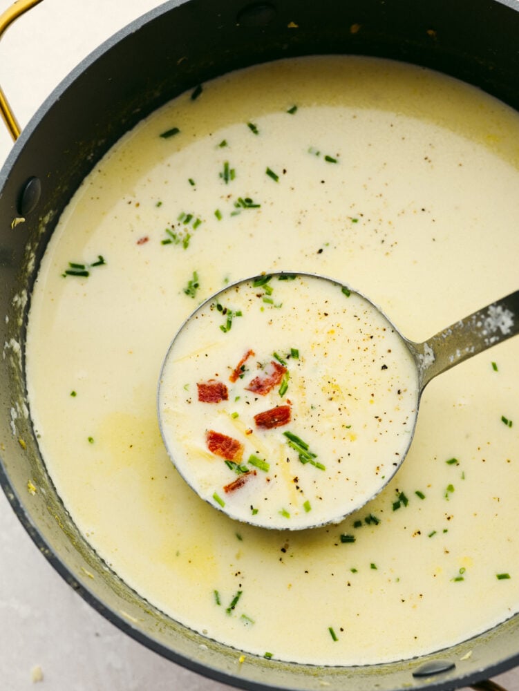 Cauliflower soup is so creamy and delicious. It's made from simple ingredients so that you can load it up with your favorite toppings or enjoy it on its own. It will be a hit with the entire family! Cauliflower soup in a pot with a ladle.