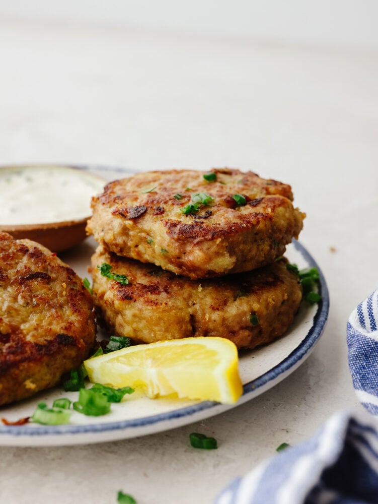 These chicken patties are crispy and perfectly browned on the outside and juicy and tender on the inside. They are a delicious addition to any meal for any occasion! A stack of chicken patties on a plate.