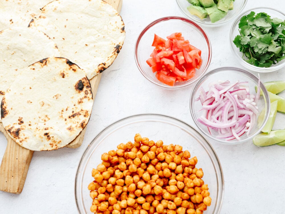 Chickpea tacos are a great way to get your daily protein and all the Tex-Mex flavors that you crave! These flavorful tacos are loaded with fresh veggies and topped off with a creamy cilantro drizzle! Small tortillas and various vegetable toppings.