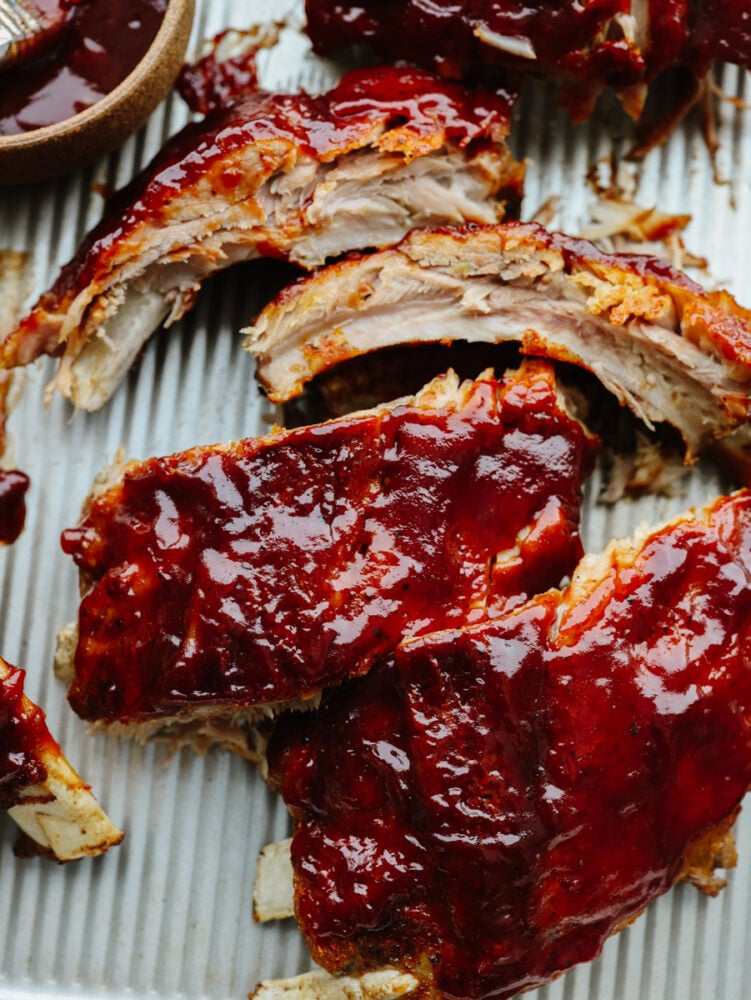 These Instant Pot ribs are fall off the bone tender, easy to make, and loaded with flavor! Enjoy straight them out of the pressure cooker slathered with your favorite bbq sauce! A close up of instant pot ribs with BBQ sauce on them.