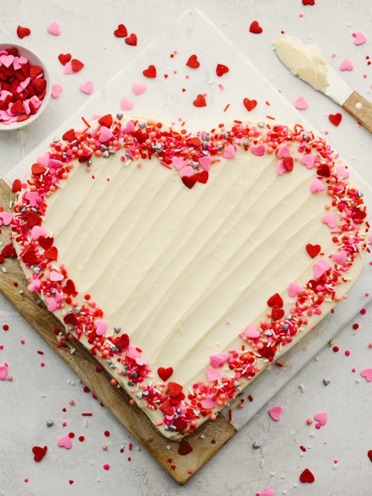 Festive and delicious, this heart-shaped cake is ready to impress your valentine! You can't go wrong with a red velvet cake topped with luscious cream cheese frosting! A whole heart-shaped cake, topped with festive sprinkles.