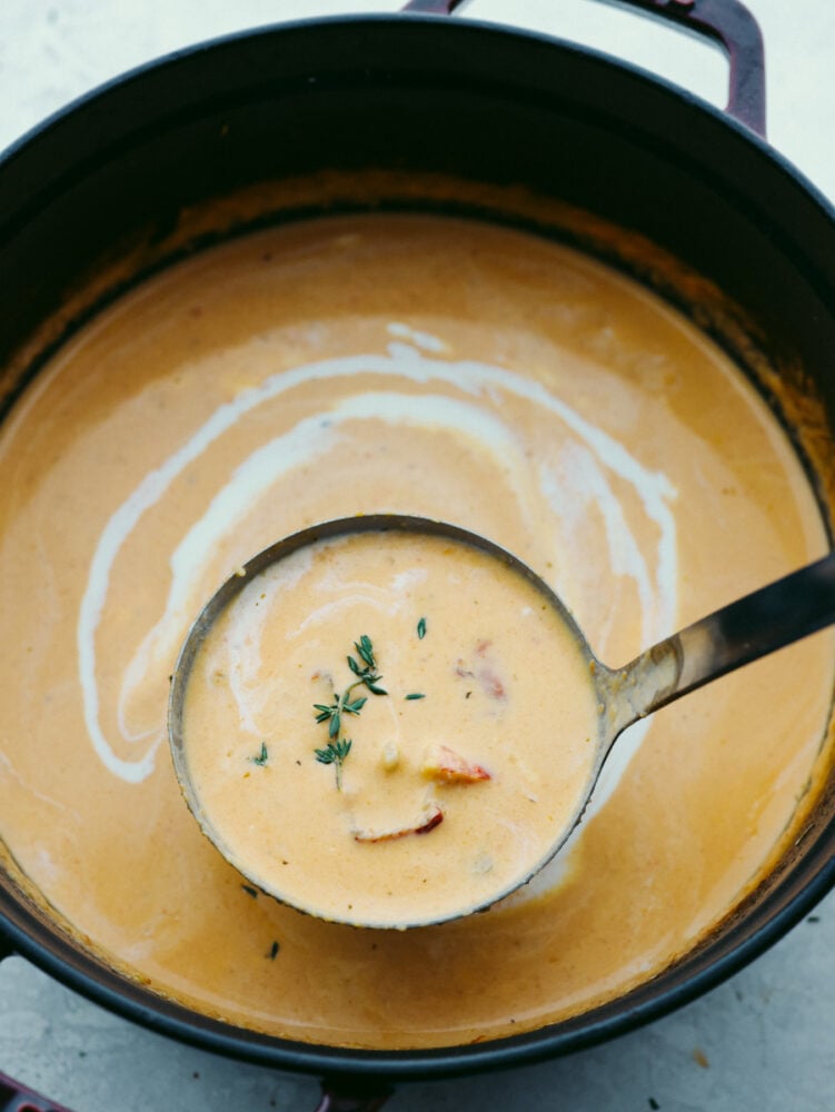 Classy, elegant, and insanely delicious, this lobster bisque needs to make its way to your dinner menu as soon as possible! This recipe is absolutely divine and not one you will want to miss out on! A pot of lobster bisque with a ladle.