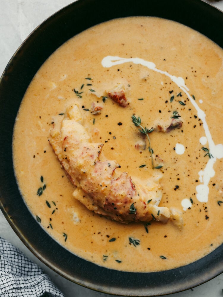 Classy, elegant, and insanely delicious, this lobster bisque needs to make its way to your dinner menu as soon as possible! This recipe is absolutely divine and not one you will want to miss out on! A close up of a bowl of lobster bisque.