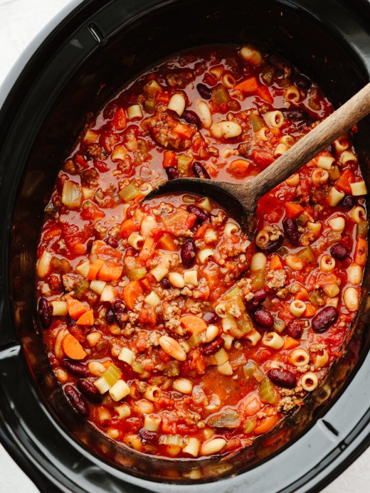 Slow cooker Pasta e Fagioli soup is a rich and hearty Italian soup loaded with pasta, vegetables, beans, and lean ground beef. It's hearty, comforting, and oh so delicious! A slow cooker filled with pasta e fagioli all cooked.