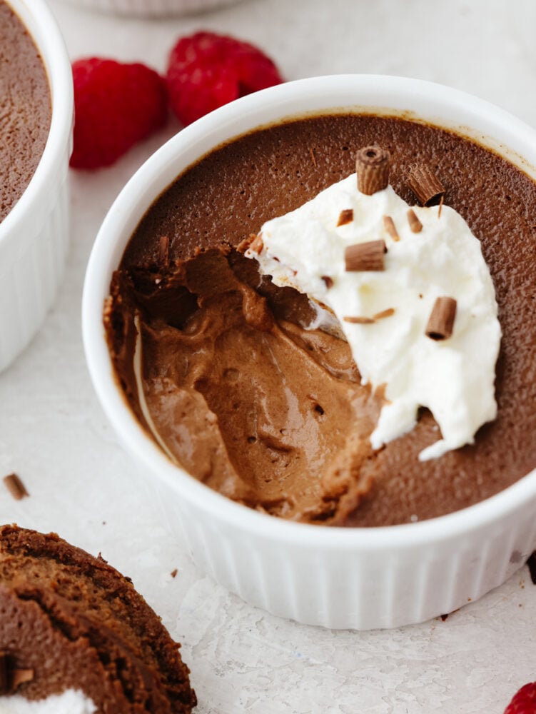 Pot de crème is silky smooth and loaded with chocolate flavor. Perfectly proportioned in individual servings, you can end any meal on a high note with this delectable dessert! Pot de creme in a ramekin with a scoop taken out.