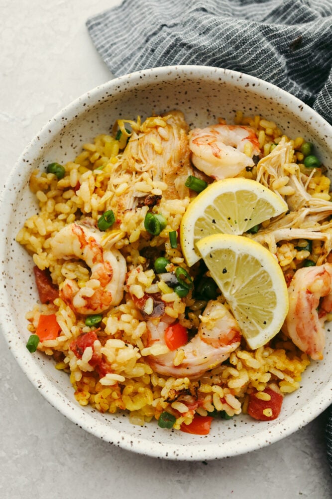 This chicken and shrimp paella is the perfect comfort food! Rich in flavor, this paella is so delicious that you won't be able to stop yourself from coming back for seconds! Chicken and shrimp paella in a bowl.