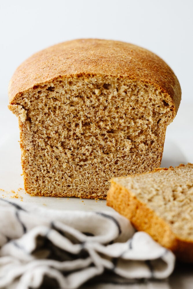One slice of this amazing wheat bread and you'll be addicted! It's warm, soft, and tender, sweetened to perfection with honey! Front view of a loaf of wheat bread.