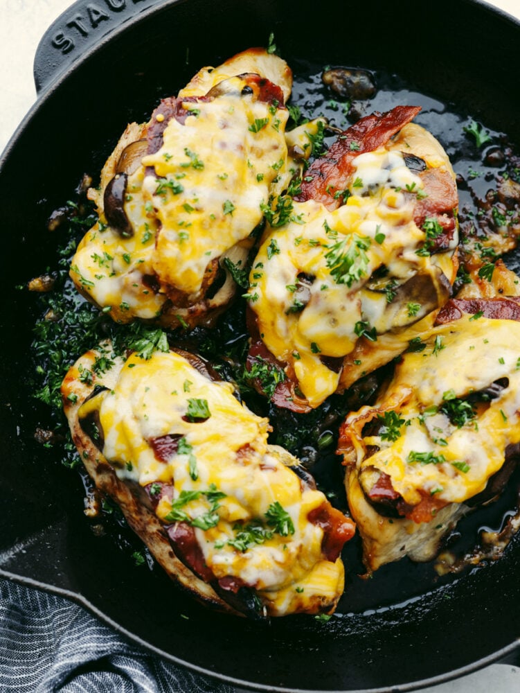 This copycat Alice Springs Chicken is a zesty, cheesy dinner that the whole family will enjoy! It's super easy to make and loaded with toppings like honey mustard, bacon, and colby jack cheese! 4 pieces of Alice Springs Chicken in a skillet.