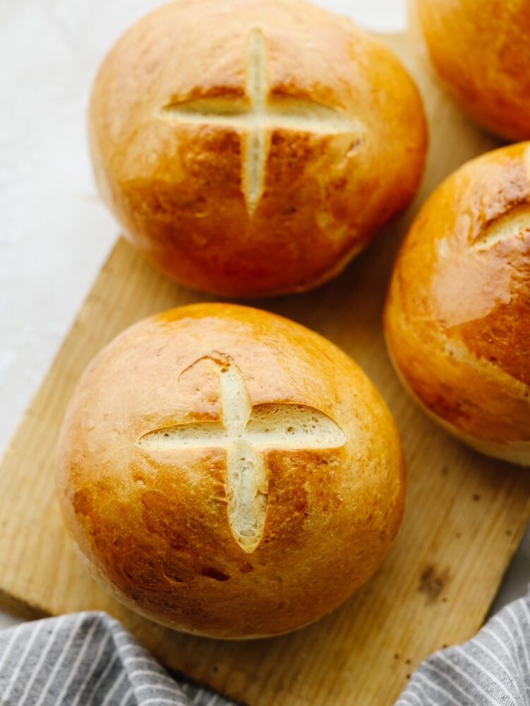 Homemade bread bowls are a simple and delicious way to take all of your soups to the next level! These bread bowls are perfectly crisp on the outside and soft and airy on the inside. 3 bread bowls on a wooden cutting board that are cooked and ready to eat.