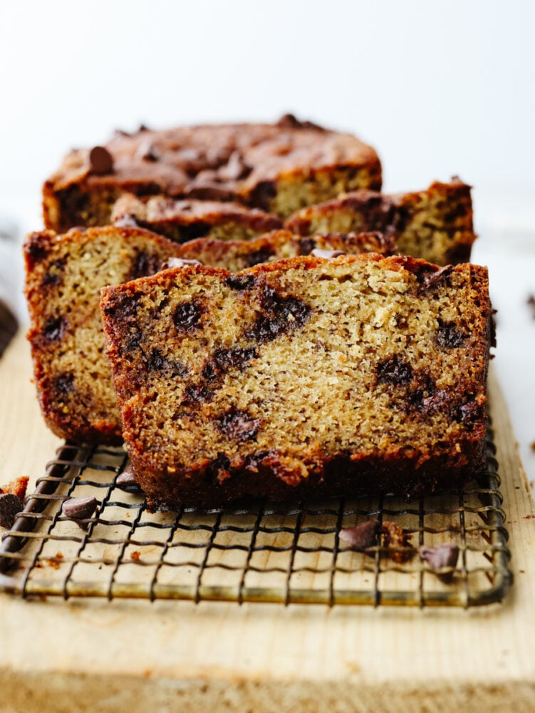 This chocolate chip banana bread takes a family favorite and takes it to the next level! It's moist and packed with flavor. I bet that you won't be able to stop at just one slice! Sliced chocolate chip banana bread on a cooling rack.
