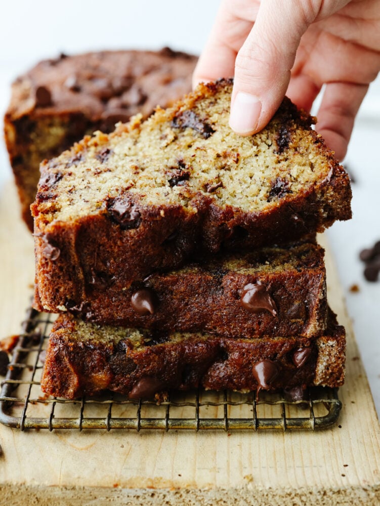 This chocolate chip banana bread takes a family favorite and brings it to the next level! It's moist and packed with flavor. I bet that you won't be able to stop at just one slice! A stack of sliced chocolate chip banana bread.