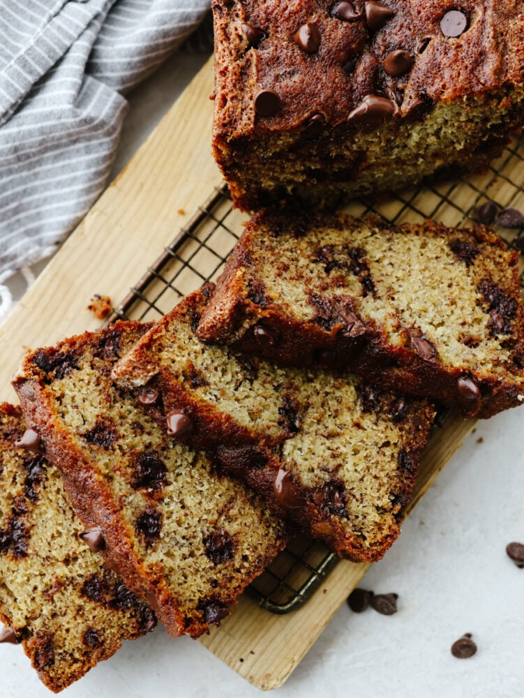This chocolate chip banana bread takes a family favorite and brings it to the next level! It's moist and packed with flavor. I bet that you won't be able to stop at just one slice! The top view of a loaf of banana bread with a few slices cut on a cooling rack.