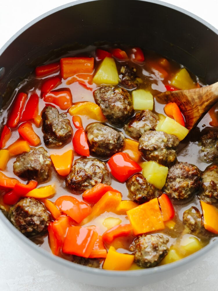 Hawaiian meatballs are the PERFECT main course for your dinner! You don't want to miss out on these! They are drenched in the most delicious sauce and packed with flavor. A pot filled with sauce, meatballs and vegetables.