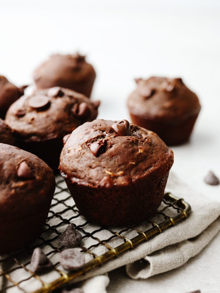 These double chocolate muffins are a healthier choice than some others you may find out there! They are still packed with delicious ingredients, and the chocolate flavor will blow you away. Double chocolate muffins on a cooling rack.