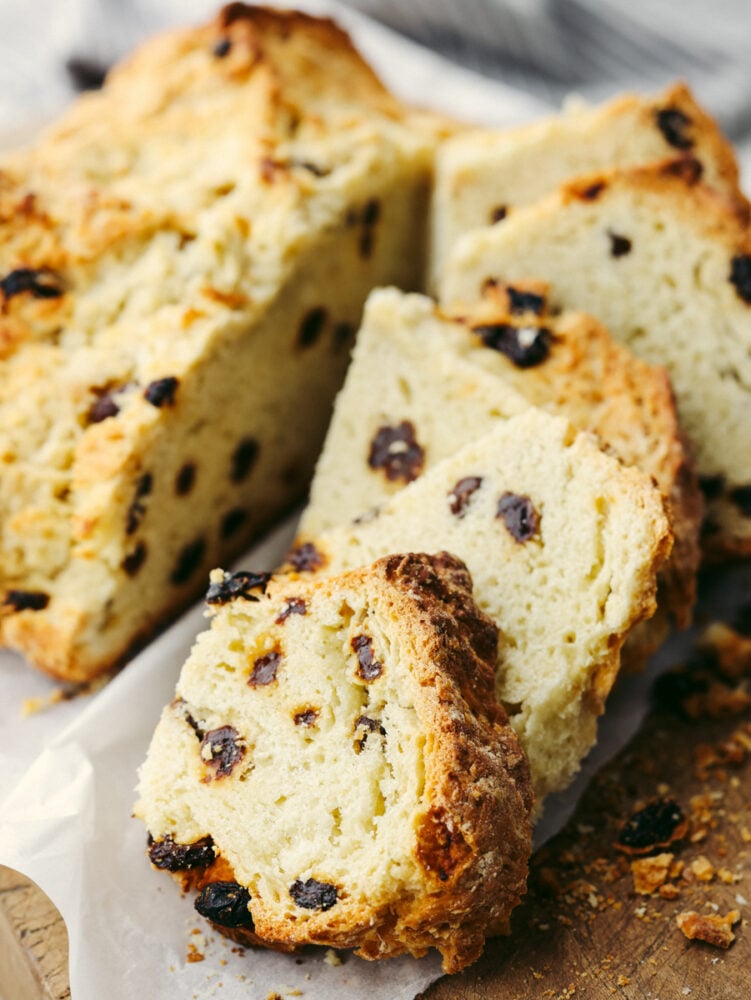 This traditional no yeast bread recipe is a crumbly dense bread with a slightly sweet taste. With only a few pantry and refrigerator staples required, this delicious traditionalย soda bread can be made easily and is one everyone will enjoy. A loaf of soda bread sliced and ready to eat.