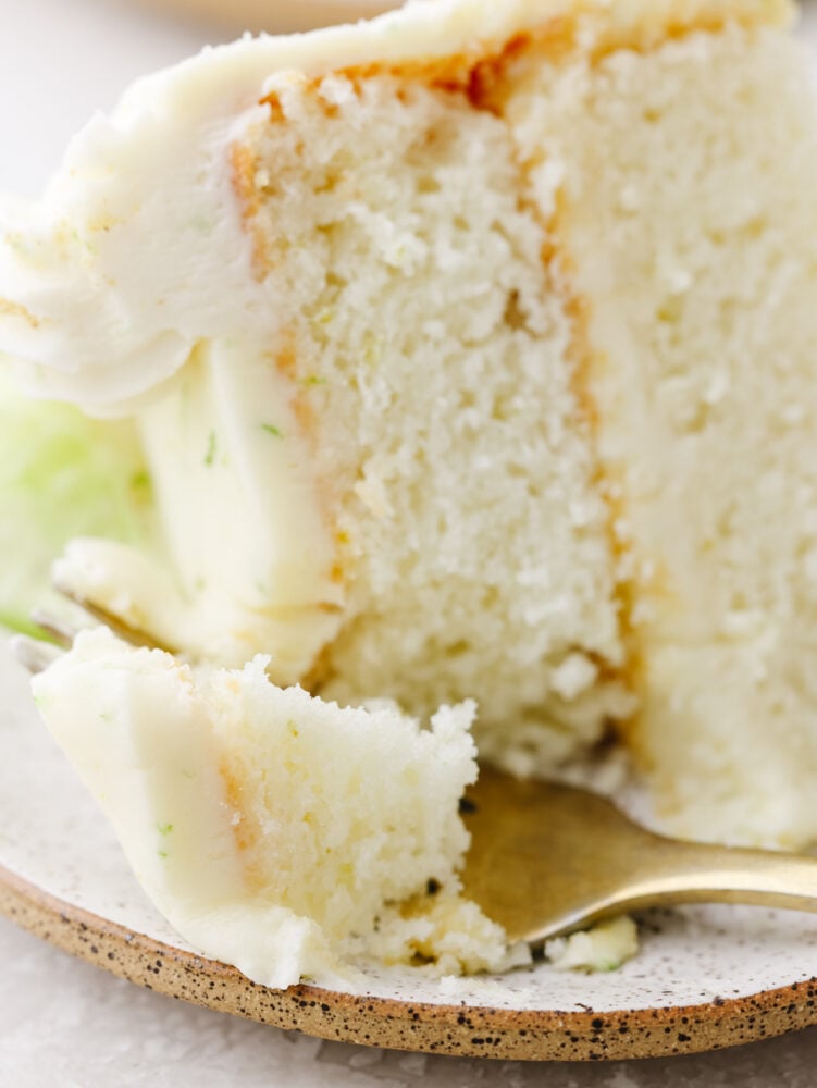 This moist key lime cake with cream cheese frosting is the perfect blend of tangy and sweet! You won't be able to stop at one slice! Closeup of a bite of key lime cake.
