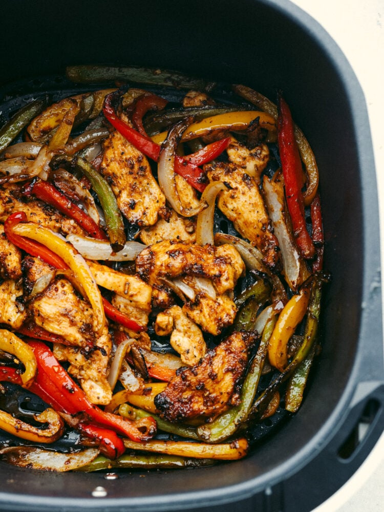These air fryer fajitas are packed to the brim with flavor but only take a few minutes to make! They are perfect for those on-the-go, busy nights, and everyone will go crazy over them! Chicken fajitas cooked in an air fryer basket.