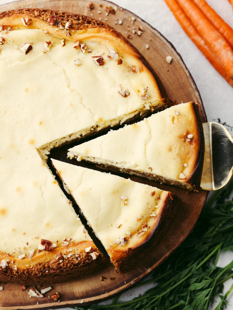 Nutty, sweet, and decadent, each bite of carrot cake cheesecake is a dream! This dessert is so good you wonโt want to stop at one piece! Top-down view of 2 cut pieces of cheesecake.