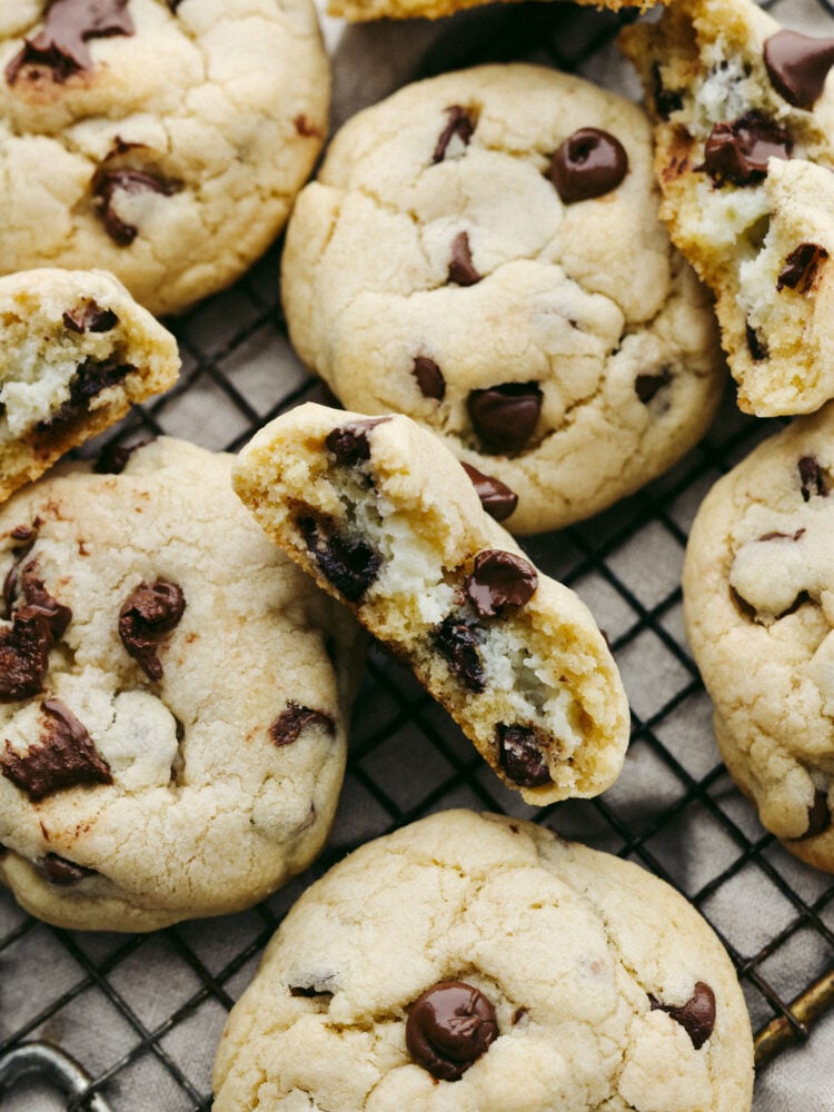 These are everything you love about chocolate chip cookies filled with creamy cheesecake! They're soft, fluffy, and the best twist on a classic cookie. Closeup of a cheesecake stuffed chocolate chip cookie broken in half.