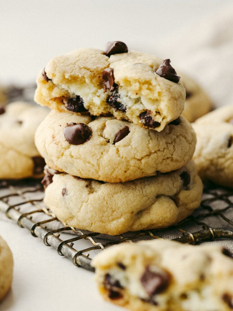 These are everything you love about chocolate chip cookies filled with creamy cheesecake! They're soft, fluffy, and the best twist on a classic cookie. 3 cookies stacked on top of each other.