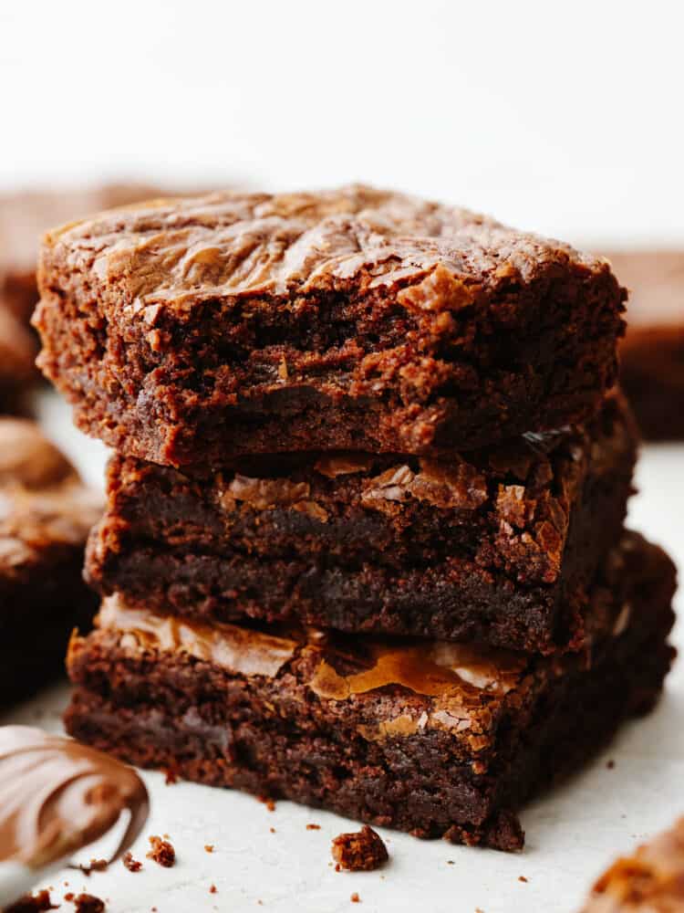 This super easy 3-ingredient brownie recipe is the only one you'll ever need! These brownies are rich and fudgy, the perfect solution for when you're craving chocolate! A stack of 3 brownies, one with a bite taken out of it.
