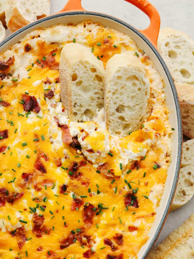 Creamy and packed with flavor, this baked bacon dip is to die for! You will love all of the ingredients that come together to make it the best dip that you've ever had! 2 slices of a crostini in baked bacon dip.