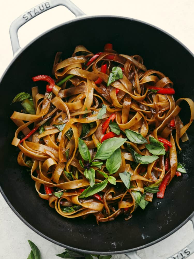 These drunken noodles (or spicy Thai noodles) are filled with delicious flavors! Coated in a perfectly savory sauce, these noodles will satisfy any Thai food craving! A pan filled with cooked drunken noodles.