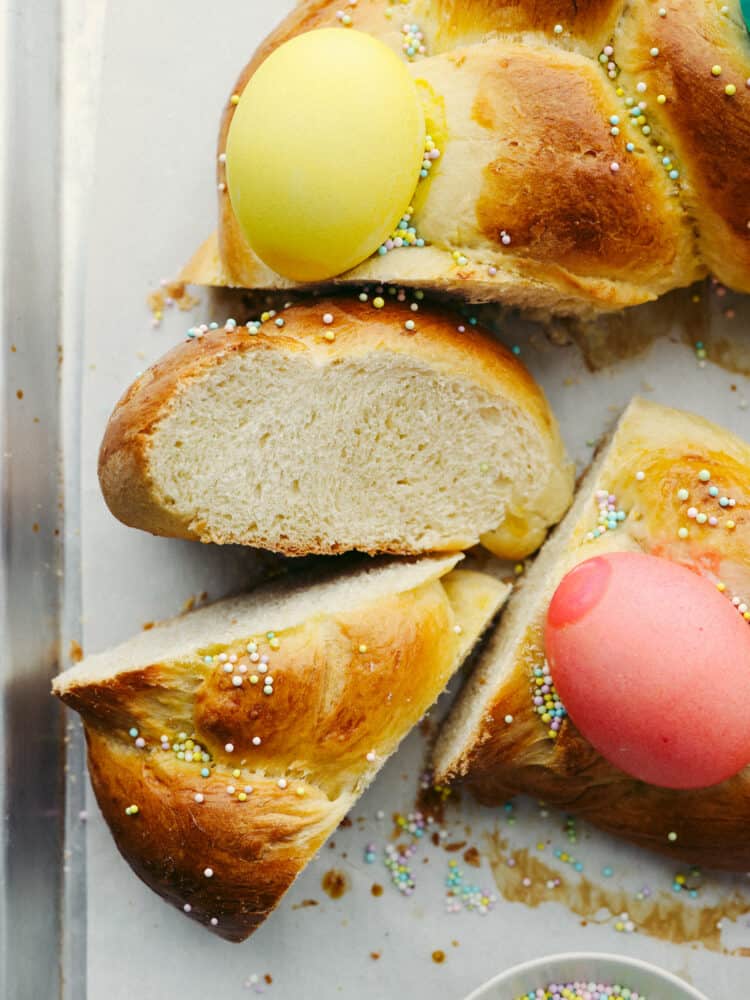 Easter bread is fluffy, sweet, and almost too cute to eat! This festive bread is sure to be a hit with its soft, tender texture and colorful presentation! Closeup of bread cut into multiple pieces.