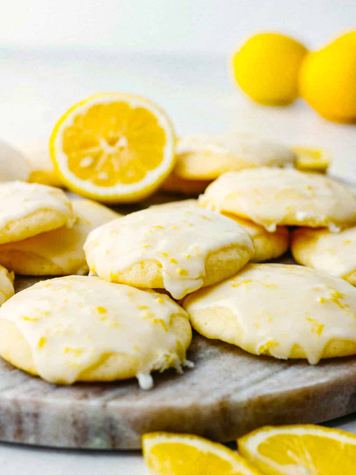 These lemon ricotta cookies are a lemon lover's dream come true! They are soft, moist, and drizzled with amazingly fresh lemon glaze. You will want to serve these up every chance that you get! Angle shot of stacked lemon ricotta cookies.