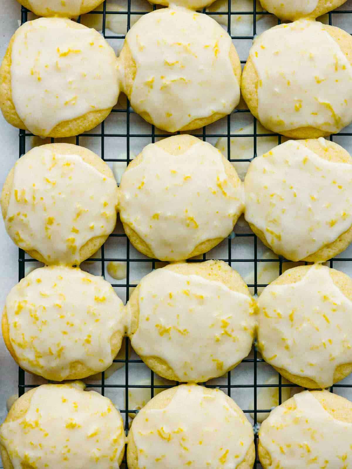 These lemon ricotta cookies are a lemon lover's dream come true! They are soft, moist, and drizzled with amazingly fresh lemon glaze. You will want to serve these up every chance that you get! Overhead shot of lemon ricotta cookies on a cooling rack.
