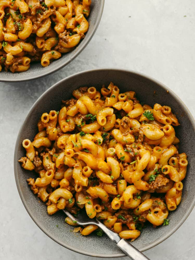A classic comfort dish that your entire family will love is this homemade hamburger helper! Cheesy noodles, meat, and delicious flavor make this recipe a go-to for any family with picky eaters! Hamburger helper in a bowl with a silver fork.