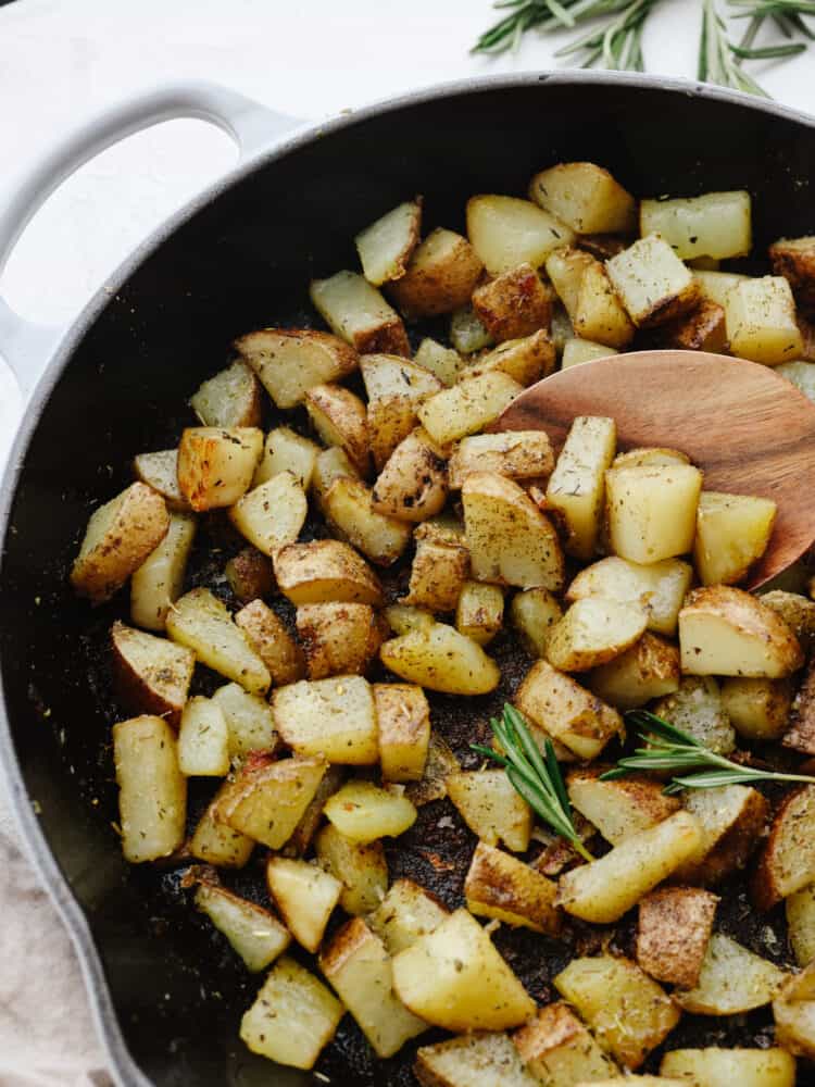 Tossed with Italian herbs and olive oil, this simple pan-fried potato dish is going to be a new dinner favorite. Serve them for breakfast or alongside a hearty dinner! Closeup of pan fried potatoes in a skillet.