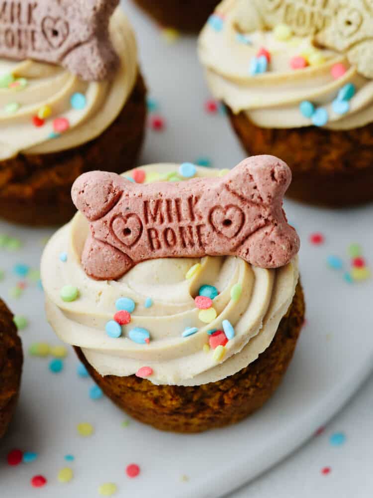 Pupcakes are a dog-friendly dessert your 4-legged friend will go crazy over! They're super easy to make and full of healthy ingredients for your pup! A peanut butter dog cupcake topped with frosting and a dog treat.