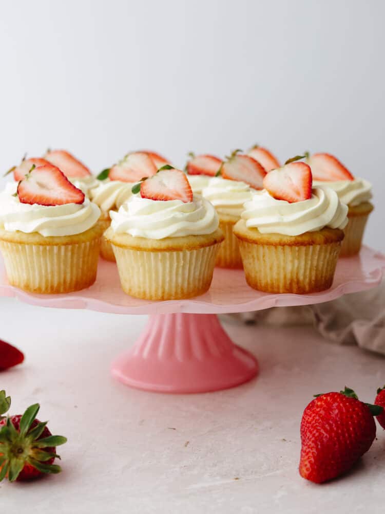 Refreshing and delicious, these fresh strawberry shortcake cupcakes are so yummy and look like a showstopper! Once you have one, you won't be able to resist reaching for a second! Strawberry shortcake cupcakes on a pink cake platter.