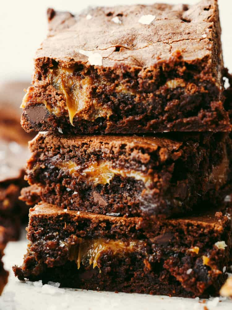 These salted caramel brownies are perfectly fudgy and moist brownies with an oozing salted caramel center. These will be one of the best brownies you sink your teeth into! A zoomed in shot of salted caramel brownies with a bite taken out of the top one.