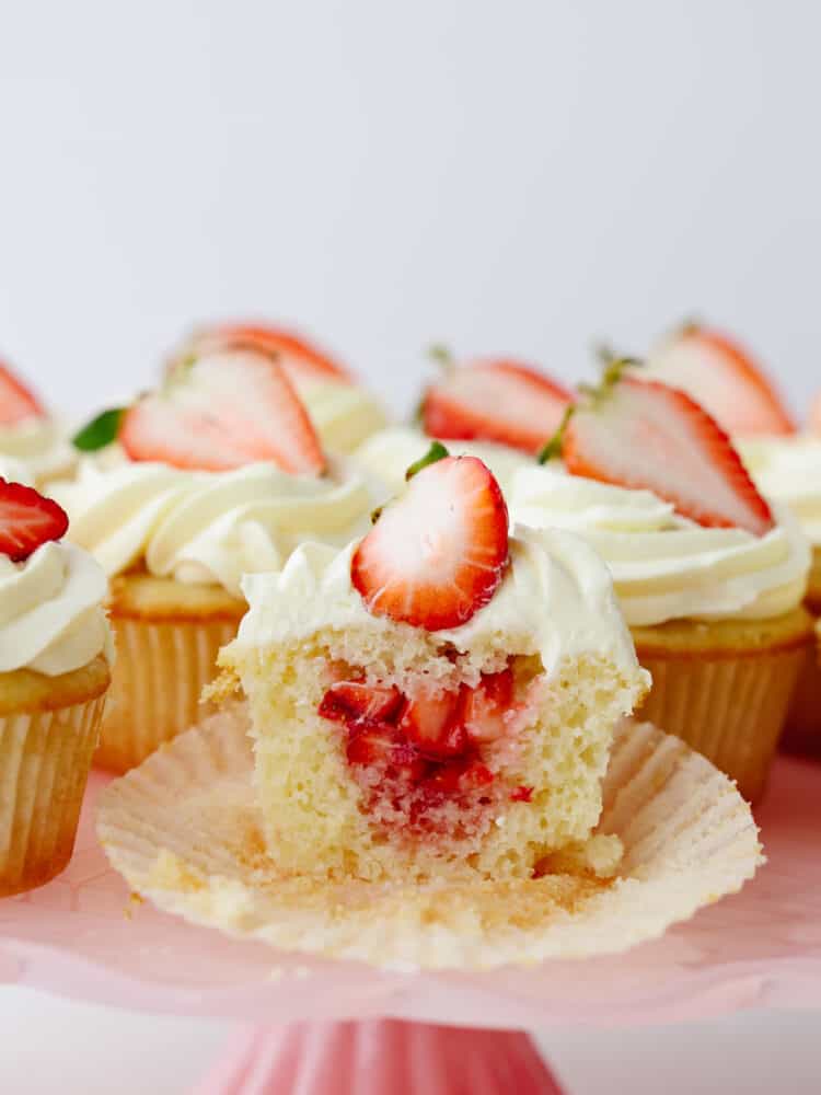 Refreshing and delicious, these fresh strawberry shortcake cupcakes are so yummy and look like a showstopper! Once you have one, you won't be able to resist reaching for a second! A strawberry shortcake cupcake sliced so that you can see the filling inside.