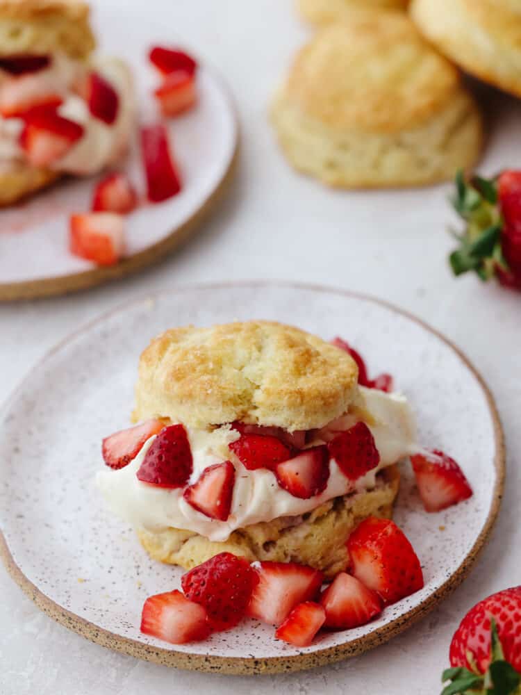 Strawberry Shortcake is an easy to make, simple sweet biscuit base, sweetened whipped cream, and fresh strawberries dessert! It's the perfect summer dessert and great for making ahead to serve to guests on a whim. A plate of strawberry shortcake.