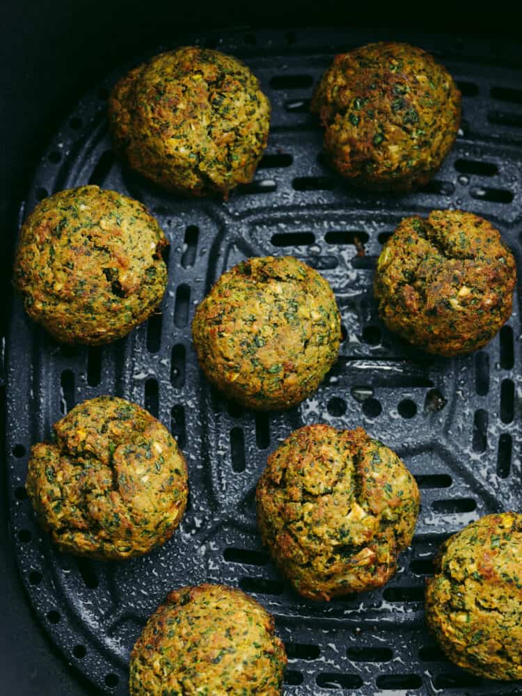Delicious air fryer falafel is a healthier and easier version without having to fry anything in oil. With a crispy outside shell and a tender center, this falafel is packed with flavor and nutrition. Overhead view of cooked crispy falafel balls in the basket of the air fryer.