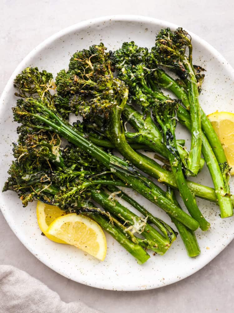 This super-easy side dish is delicious, full of flavor, and has the perfect crispy crunch on the outside. This air fryer broccolini takes less than 10 minutes to make and can be paired with just about any meal! A plate of cooked broccolini, ready to eat.
