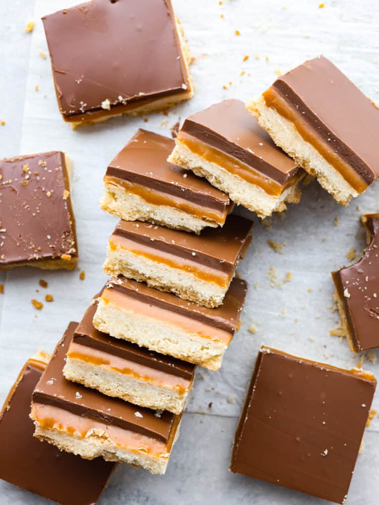 These taste exactly like a Twix bar with a delicious shortbread crust, caramel center, and a chocolate layer on top. The best part about them is that you can make them right at home! The top view of Twix bars cut into squares and laid on theirs sides so that you can see the layers.