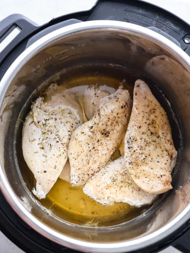Forgot to thaw the chicken? No problem! This instant pot frozen chicken recipe turns rock-solid breasts into tender, juicy perfection in no time. Dinner crisis averted! The top view of seasoned. frozen chicken breasts in an instant pot.