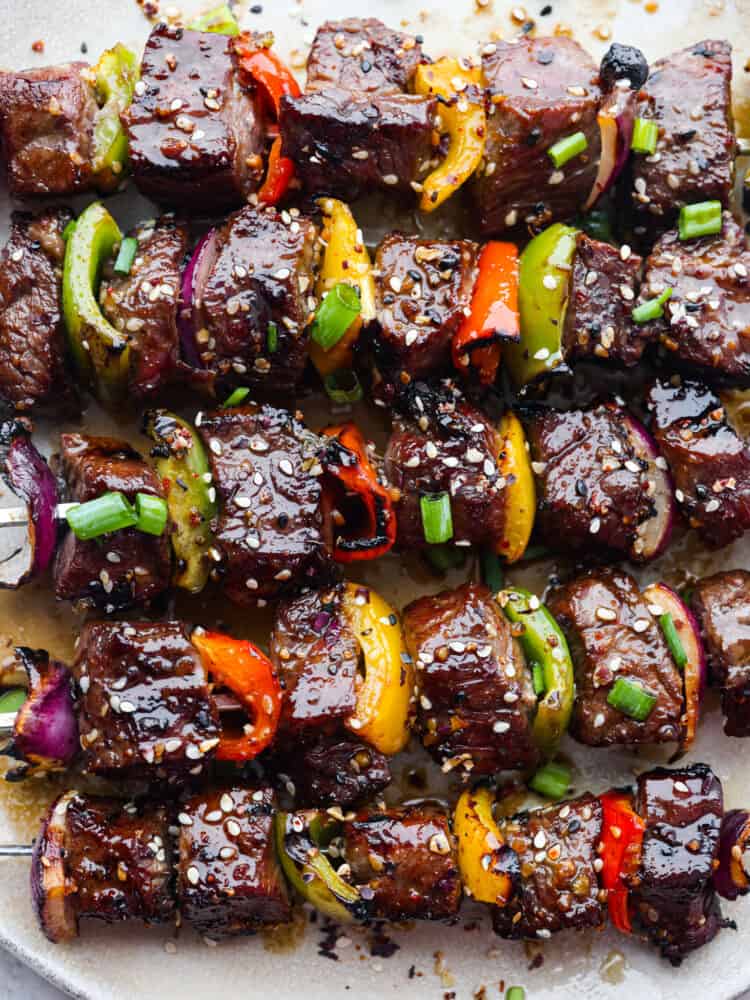 Grilled Asian Garlic Steak Skewers are marinated in a delicious Asian garlic sesame sauce and grilled to tender and juicy perfection!ย A fun and unique addition to any gathering! A closeup of cooked Asian garlic steak skewers.