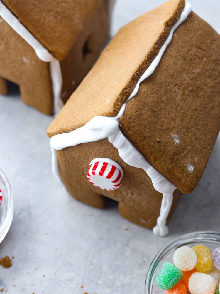 Nothing says holiday season like a Gingerbread house sitting on the counter! This recipe includes the recipe for gingerbread, a template to print out the ginger bread house pieces, and how to make the royal icing. This is the perfect recipe for the whole family to enjoy! A top view of a gingerbread house with a peppermint candy on the front.