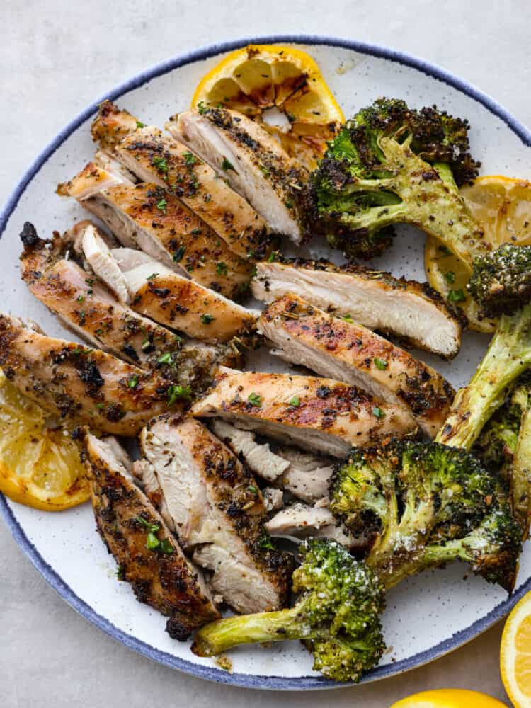 This easy grilled lemon chicken recipe just requires a few ingredients and grills up in just a few minutes! It's tender and juicy and packed with lots of fresh flavors! A plate with sliced chicken and grilled broccoli.