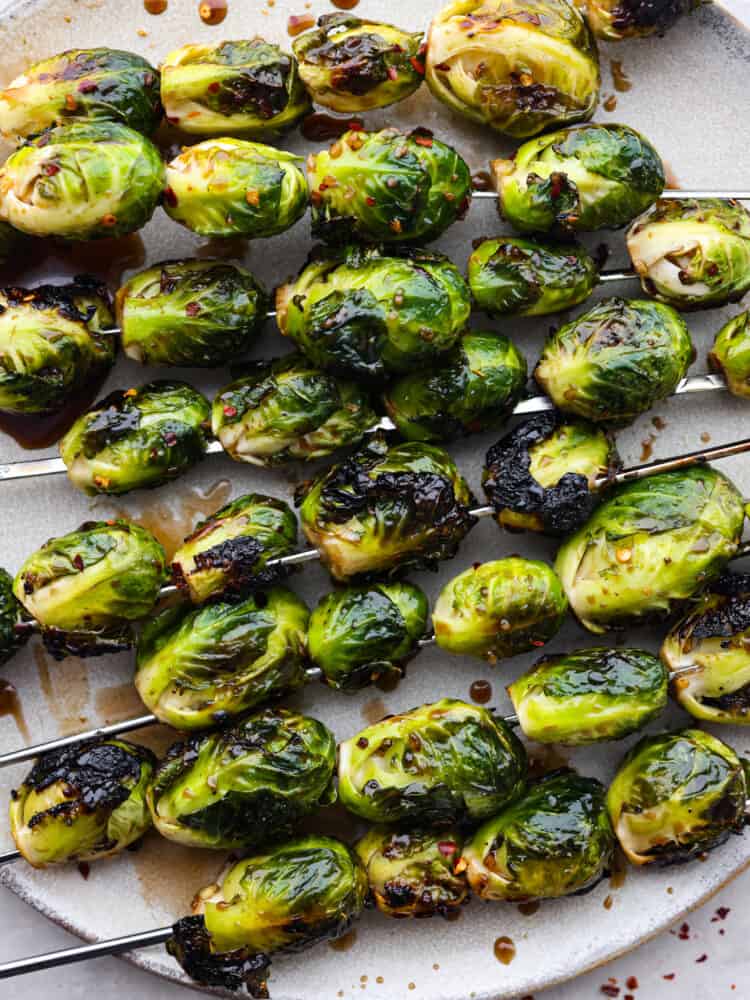 Crispy on the outside, tender on the inside, and topped with a balsamic honey glaze, these grilled brussels sprouts are the best side dish for summer and early fall! The amazing tangy flavor and tender, caramelized texture of these brussels sprouts will make even the pickiest of eaters a fan. Closeup of brussels sprouts skewers.