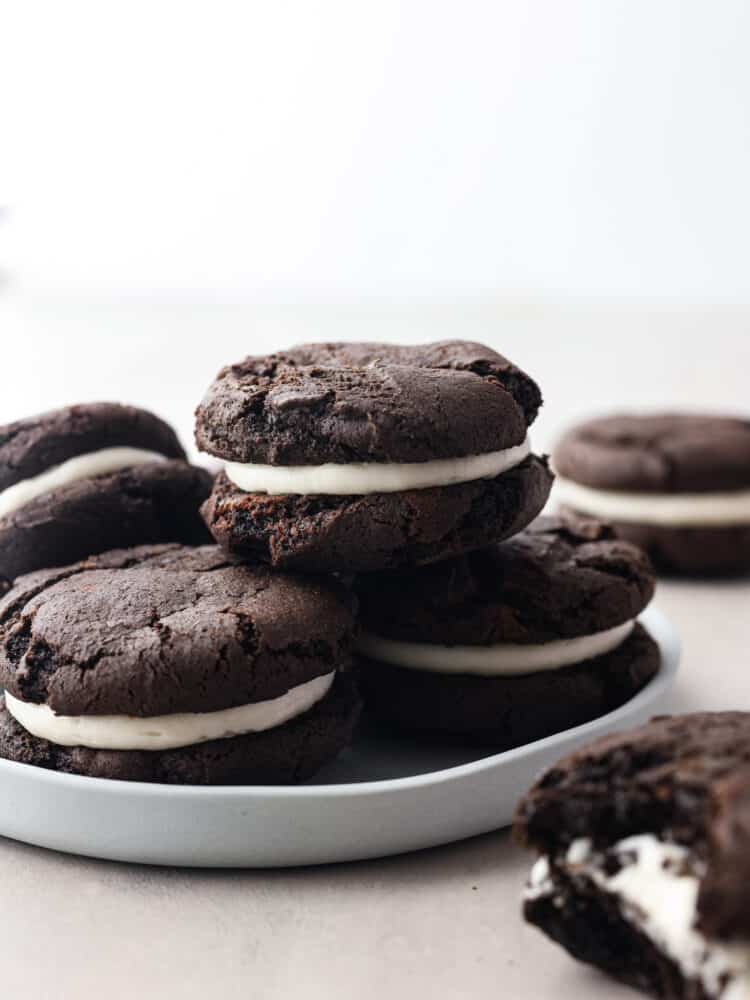 Get ready to enjoy the best homemade cookie out there! These homemade cakesters are perfectly soft on the outside and filled with the BEST creamy, oreo filling. You won't be able to stop at just one! Homemade oreo cakesters stacked on a plate.